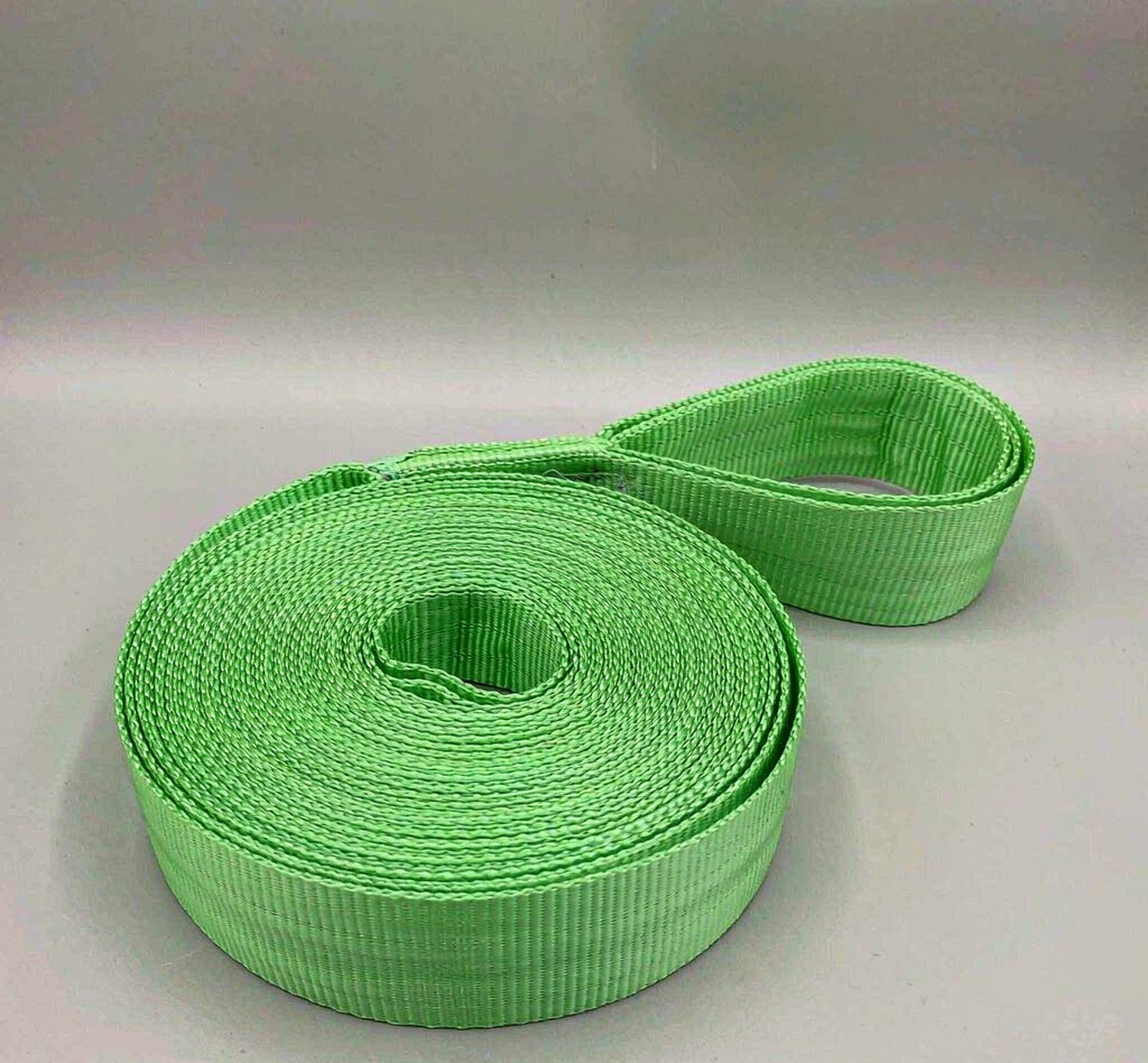 Green polyester round lifting sling coiled, colour-coded by working load limit
